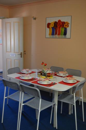 a white table with chairs and plates on it at Little Bullocks Farm in Takeley