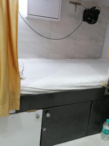 un letto in una stanza accanto a una tenda di Andheri-69-Dormitory a Mumbai