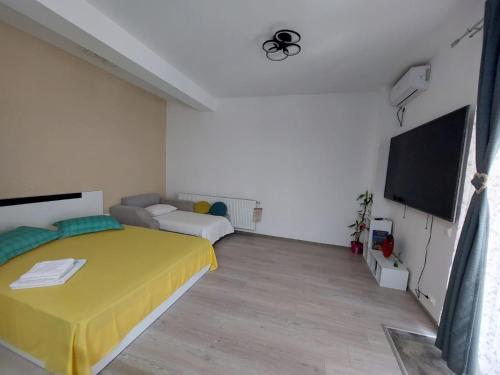 a bedroom with a bed and a flat screen tv at Casa KIM in Eforie Nord