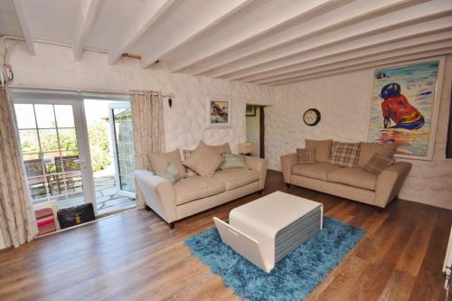 a living room with two couches and a table at Mayrose Cottage, Charming Cornish Cottage for the perfect escape... in Camelford