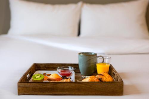 a tray of food and drinks on a bed at ibis Styles Evry Courcouronnes Hotel and Events in Evry-Courcouronnes