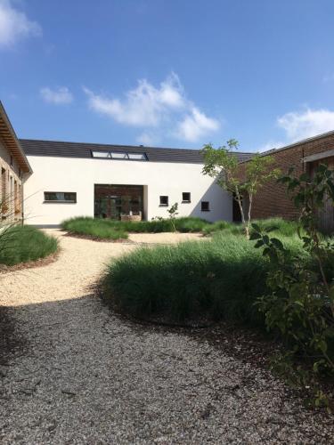 a white building with a black roof at Beautiful holiday home in renovated farm 30 mins from Pairi Daiza in Geraardsbergen