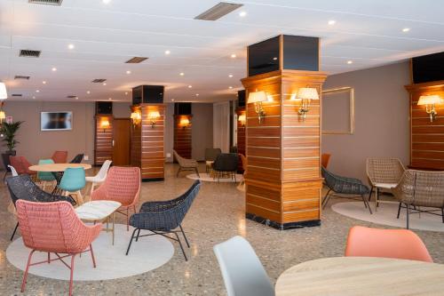a waiting area with chairs and tables in a lobby at htop Olympic #htopEnjoy in Calella