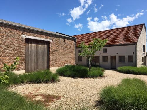 a brick building with a door on the side of it at Beautiful holiday home in renovated farm 30 mins from Pairi Daiza in Geraardsbergen