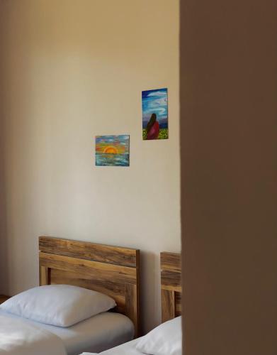 a bedroom with two beds and two pictures on the wall at Cottage Kesane in Stepantsminda