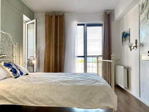 a bedroom with a large bed and a window at Apart.Boutique B. Mangalia in Mangalia