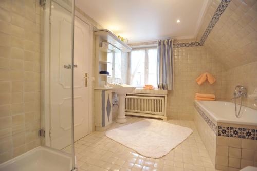 een badkamer met een douche, een wastafel en een bad bij Haus Elvi Fuchs an den alten Salzwiesen in Westerland