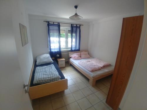 1 dormitorio con 2 camas y ventana en Monteur- und Ferienwohnung Gemmer 52qm, en Herold