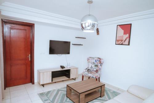 a living room with a couch and a tv and a chair at RESIDENCE OLIE OFFICIEL in Douala