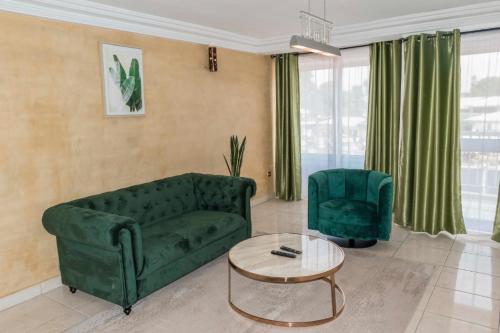 a living room with a green couch and a table at RESIDENCE OLIE OFFICIEL in Douala