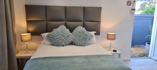 a bedroom with a large bed with two lamps at Mossel 11 Studio in Bloubergstrand