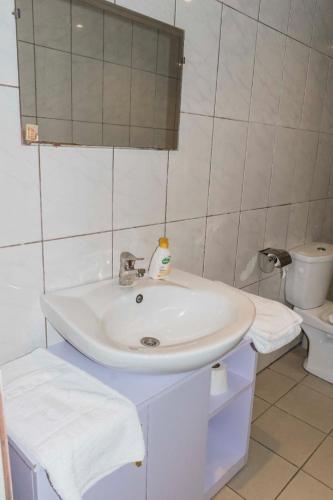 a white bathroom with a sink and a toilet at RESIDENCE OLIE OFFICIEL in Douala