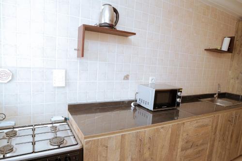 a kitchen with a stove and a microwave on a counter at RESIDENCE OLIE OFFICIEL in Douala