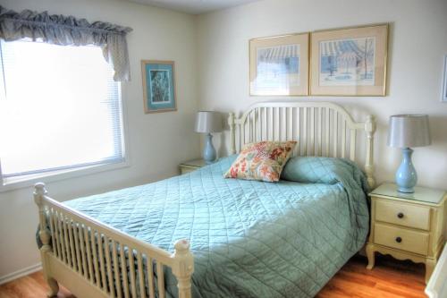 1 dormitorio con 1 cama con edredón azul y ventana en Guest Cottage 30G, en Myrtle Beach