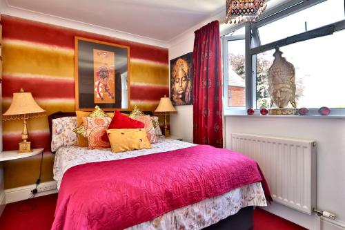 a bedroom with a pink bed and a window at The Bays Clee Rd in Cleethorpes
