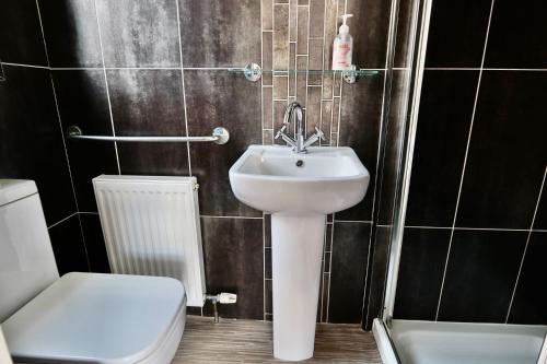 a bathroom with a white sink and a toilet at The Bays Clee Rd in Cleethorpes