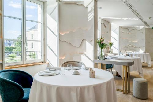 a restaurant with a white table and chairs and a sink at Fleur de Loire in Blois