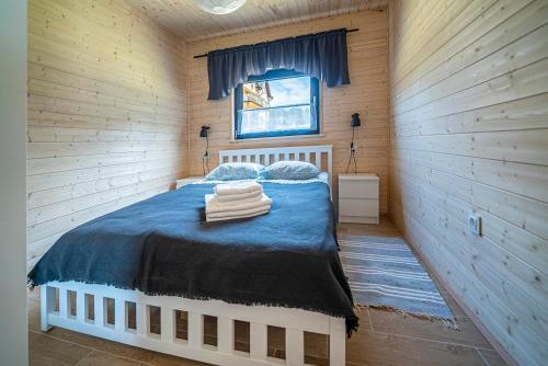 a bedroom with a bed in a wooden cabin at Dw Maryla in Ostrowo