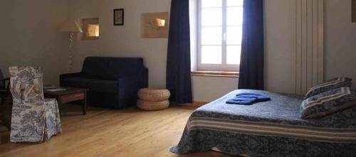 une chambre avec un lit, une chaise et une fenêtre dans l'établissement Chambres d'Hôtes Le Val de la Garenne, à Senouillac