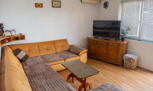 a living room with a couch and a flat screen tv at Villa ATL in Blagaj