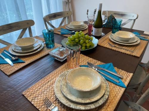 a dining room table with plates and wine glasses at Sozopolis Cliffs Luxury Seaview Villa in Sozopol