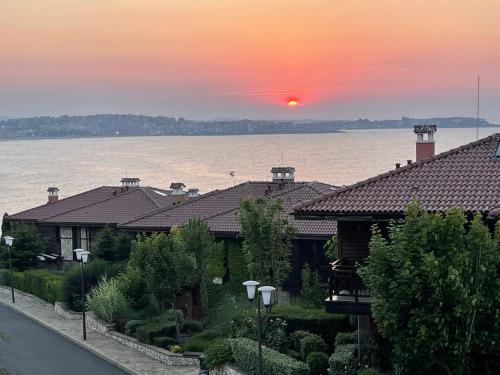 a house with the sun setting over the water at Sozopolis Cliffs Luxury Seaview Villa in Sozopol
