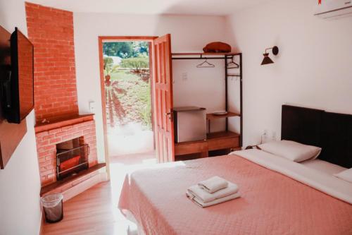 1 dormitorio con 1 cama con 2 toallas en Pousada Mirante do Penedo, en Penedo