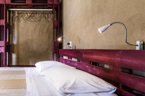 a bedroom with a bed with a red headboard and a lamp at Ventanas in Villamassargia