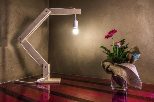 a lamp and a vase with a flower on a table at Ventanas in Villamassargia