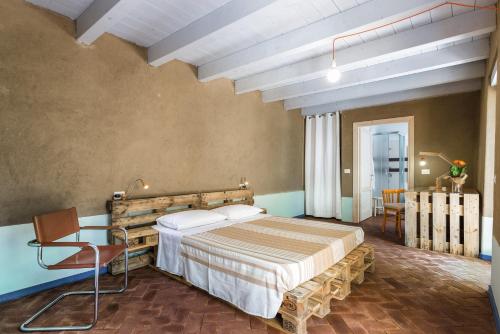 a bedroom with a bed and a chair in a room at Ventanas in Villamassargia