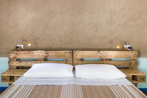 a bed with two white pillows and two lamps at Ventanas in Villamassargia