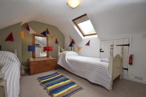 a bedroom with two beds and a ceiling with flags at Daisy Tatham Cottage in Rye