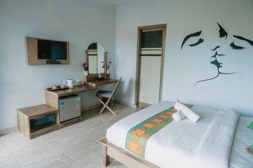 a bedroom with a bed and a desk and a tv at Kuri Garden Cottage in Nusa Penida