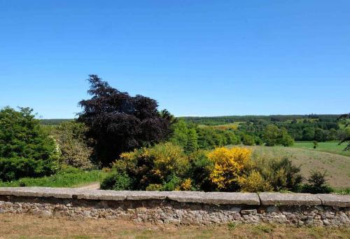 a stone wall and some bushes and trees at Mains of Orton in Fochabers