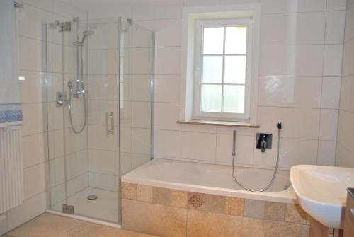 a bathroom with a shower and a tub and a sink at Ferienwohnung Obermühle in Ballstädt