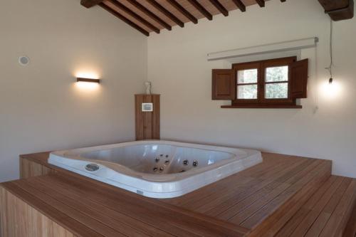 Pokój z drewnianą podłogą i dużą wanną. w obiekcie Villa Exclusive Fonte Ripa w mieście Foiano della Chiana