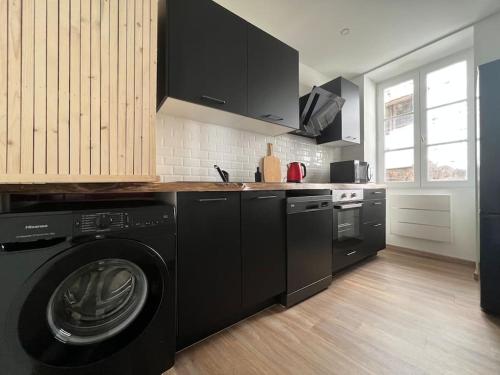 una cocina con lavadora negra y secadora. en Casa Faro - Joli T2 - Hyper Centre Brive Rue Commerçante, en Brive-la-Gaillarde