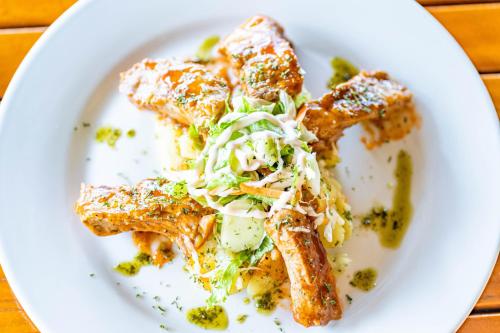 a white plate with food on a table at Grooms Beach Villa & Resort in Saint Georgeʼs