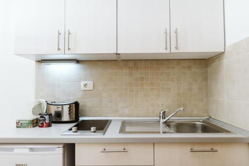 a kitchen with white cabinets and a sink at Hotel Medjugorje Irish Centre in Međugorje