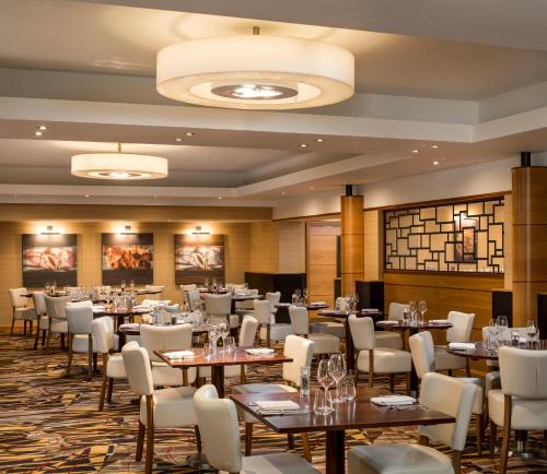 a restaurant with tables and chairs in a room at The Park Royal Hotel & Spa in Warrington