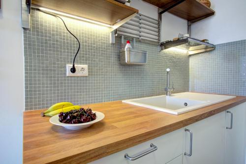eine Küche mit einem Waschbecken und einer Schale mit Obst auf der Theke in der Unterkunft Casa Rosina in Korfu-Stadt