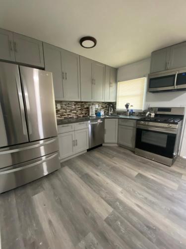 a kitchen with stainless steel appliances and wooden floors at 3 Bedrooms House Nassau County in Hempstead
