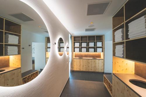 a bathroom with wooden cabinets and a curved wall at Sporthotel Pontresina in Pontresina