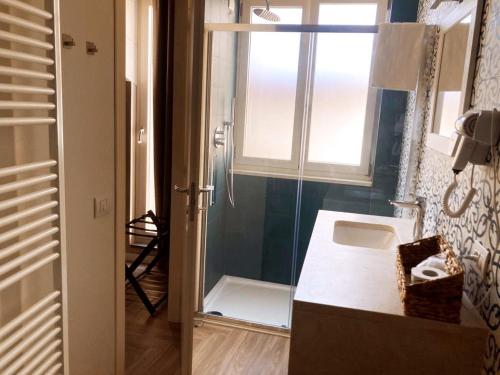 a bathroom with a shower and a sink and a window at Gatto Bianco Rooms 42 in Bergamo