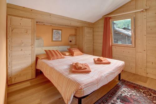 リヴィーニョにあるBaita dei ski Casinaのタオルが敷かれたベッドのある寝室