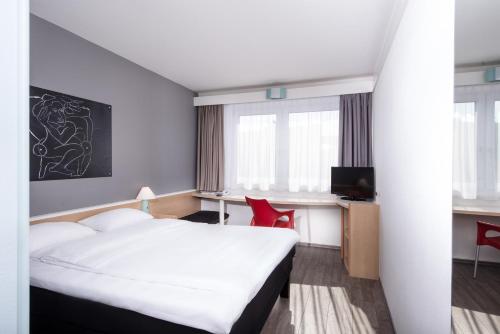 Pokój hotelowy z łóżkiem i biurkiem w obiekcie ibis Berlin City Nord w Berlinie