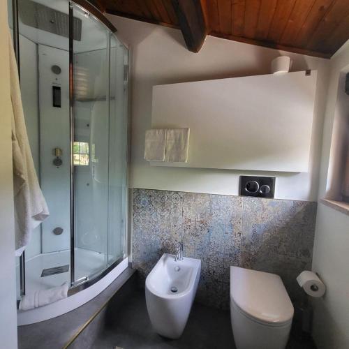 a bathroom with a toilet and a glass shower at Villa Ca' Viola Rimini in Rimini