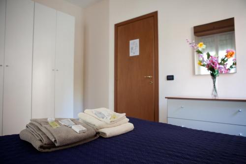 ein Schlafzimmer mit einem blauen Bett und Handtüchern darauf in der Unterkunft B&B Casa Liberty in Acqui Terme
