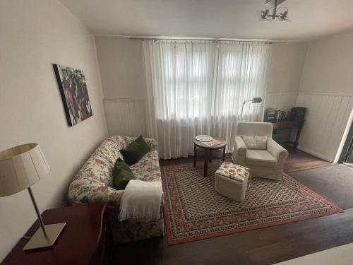 a living room with a couch and a chair at Ferienwohnung im Landhaus Labes (Stechlinsee) in Neuglobsow