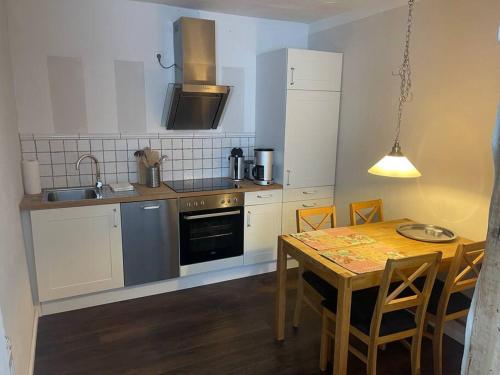 a kitchen with a wooden table and a kitchen with a dining room at Ferienwohnung im Landhaus Labes (Stechlinsee) in Neuglobsow